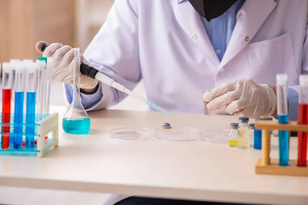 Jonge mannelijke chemicus werkt in het lab tijdens een pandemie — Stockfoto