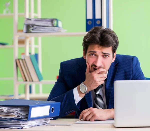 Empresario descontento con el trabajo excesivo sentado en la oficina —  Fotos de Stock