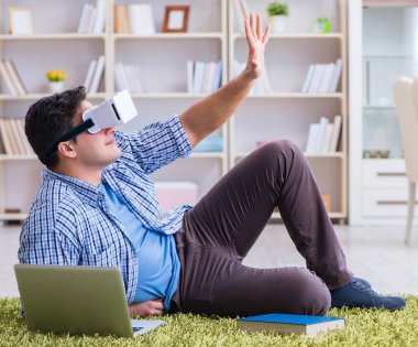 Evde sanal gerçeklik gözlükleriyle serbest çalışan bir öğrenci.