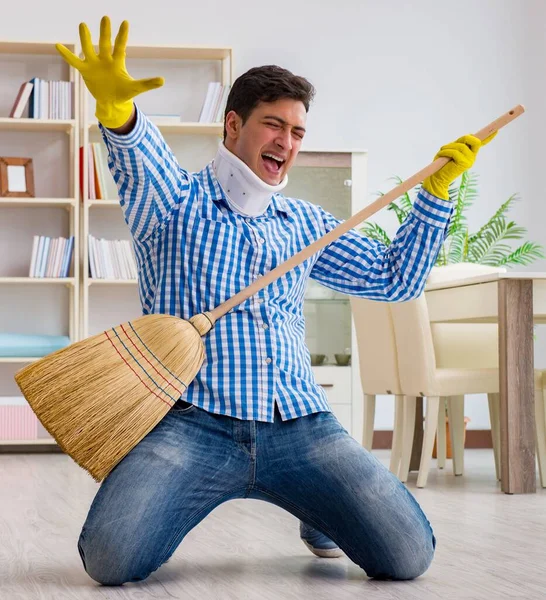 Man with neck unjury cleaning house in housekeeping concept — Stock Photo, Image