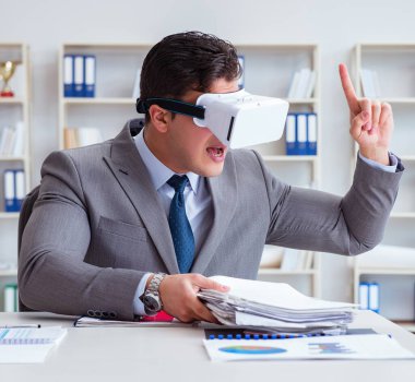 Ofiste sanal gerçeklik gözlüklü bir iş adamı var.