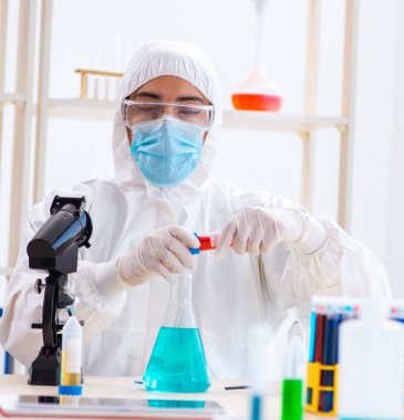 Laboratuvarda kimyasallar üzerinde çalışan genç bir kimyager.