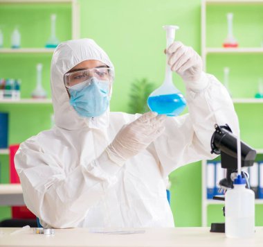 Laboratuvarda yeni bir deney üzerinde çalışan kimyager.