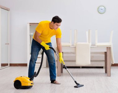 Koca adam evi temizliyor, karısına yardım ediyor.