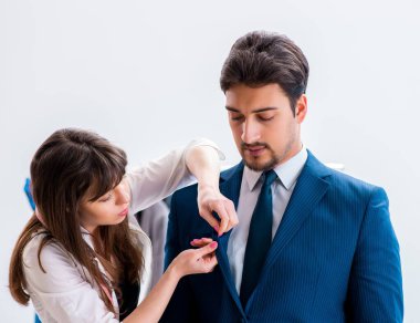 Profesyonel terzi resmi kıyafet için ölçü alıyor.