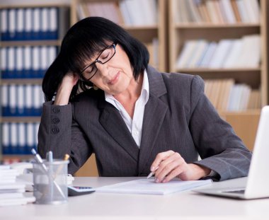 Ofiste çalışan olgun bir iş kadını.