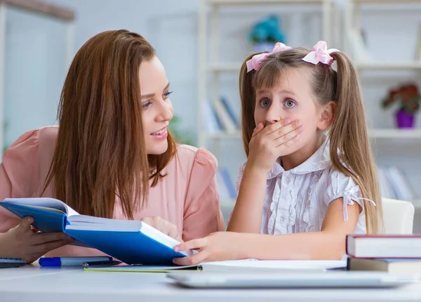 Mother helping her daughter to do homework — Stock Photo, Image