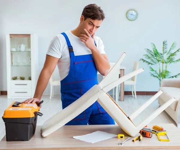 Repairman repairing broken chair at home — Stock Photo, Image