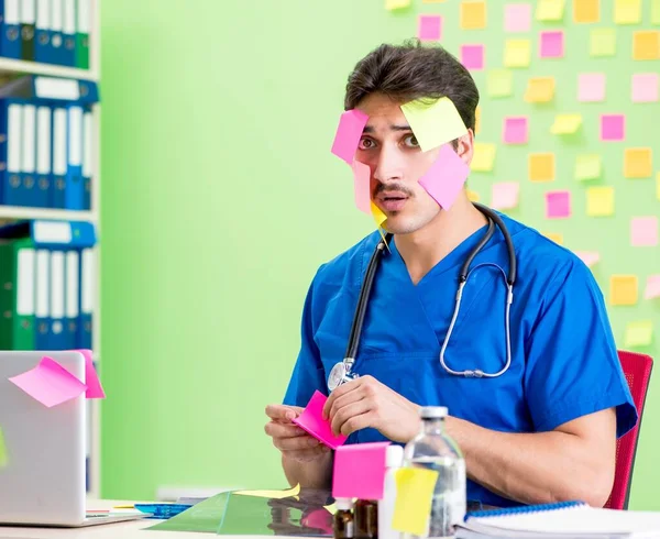 Young doctor with many reminders and urgent work — Stock Photo, Image