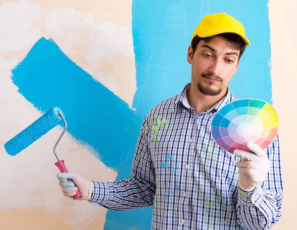 Pintor hombre pintando la pared en casa —  Fotos de Stock