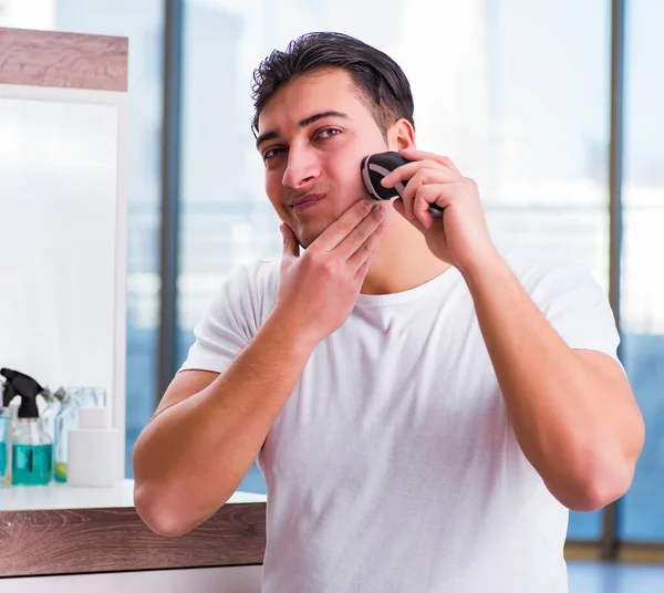 Young handsome man shaving in the morning — Stock Photo, Image