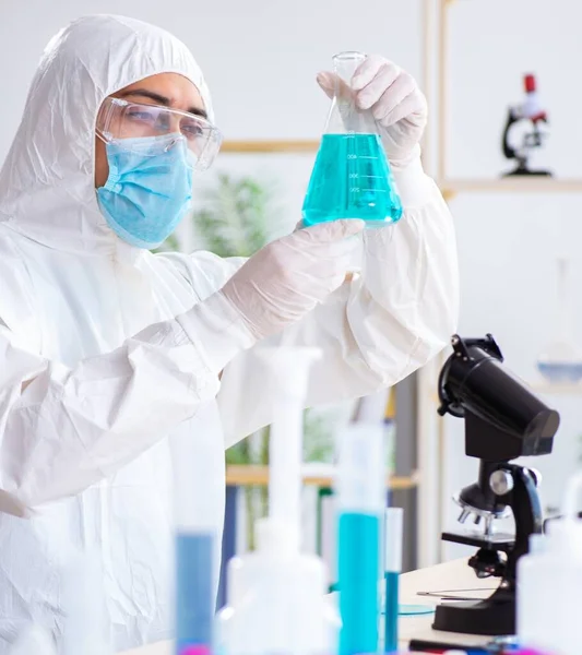 Jovem estudante de química que trabalha em laboratório em produtos químicos — Fotografia de Stock