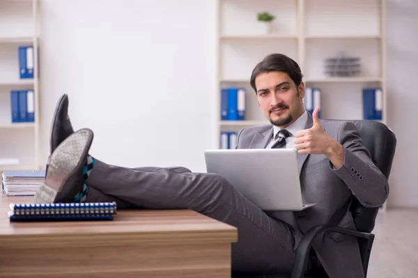 Joven empleado masculino atractivo sentado en el lugar de trabajo — Foto de Stock