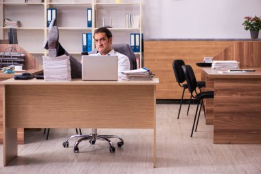 Genç erkek çalışan aşırı çalışmaktan son derece yoruldu.