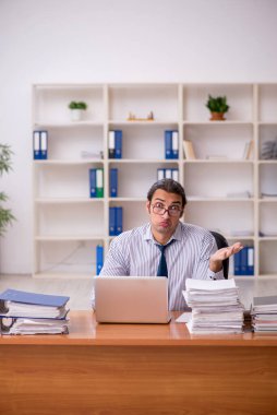 Ofisteki aşırı işten memnun olmayan genç bir erkek işçi.