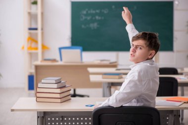 Sınıfta oturan çocuk.