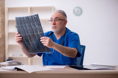 Klinikte çalışan yaşlı bir erkek radyolog.