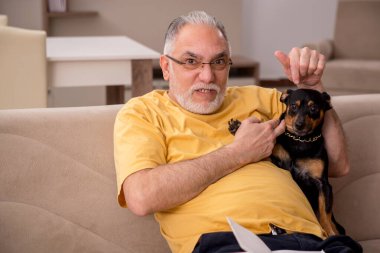 Evde köpeği olan yaşlı bir adam.