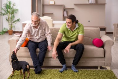 Evde köpekli iki adam.