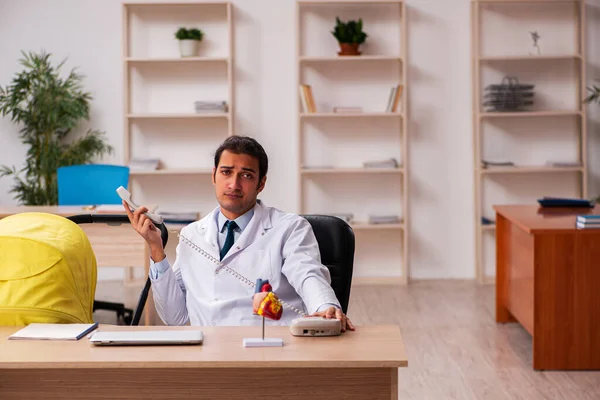 Junger Arzt kümmert sich um Neugeborenes in der Klinik — Stockfoto