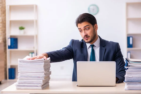 Empleado joven de negocios y demasiado trabajo en la oficina — Foto de Stock