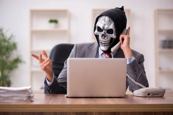 Ördög üzletember alkalmazott ül a munkahelyen — Stock Fotó