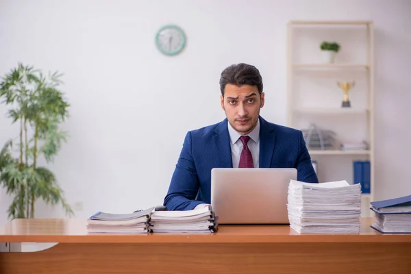 Joven hombre de negocios y demasiado trabajo en la oficina — Foto de Stock