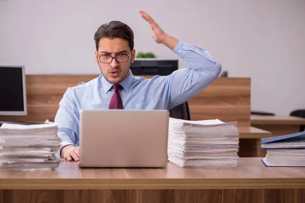 Ung manlig anställd missnöjd med överdrivet arbete på kontoret — Stockfoto