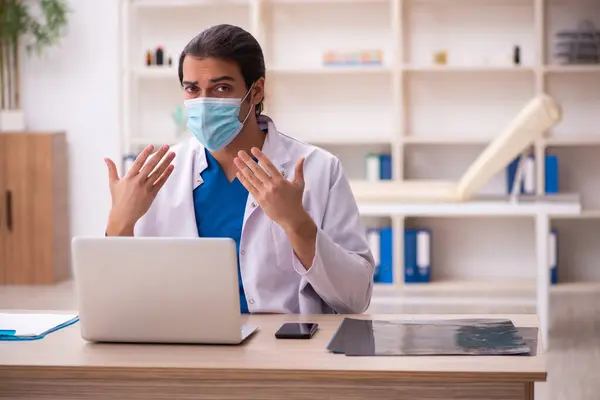 Młody lekarz noszący maskę twarzy podczas pandemii — Zdjęcie stockowe
