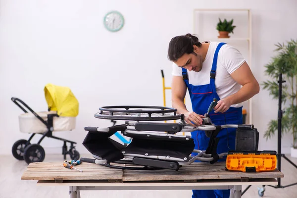 Jovem reparador do sexo masculino reparando cadeira de rodas dentro de casa — Fotografia de Stock