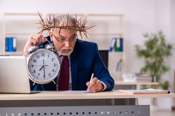 Velho empregado masculino vestindo grinalda espinhosa no conceito de gerenciamento de tempo — Fotografia de Stock