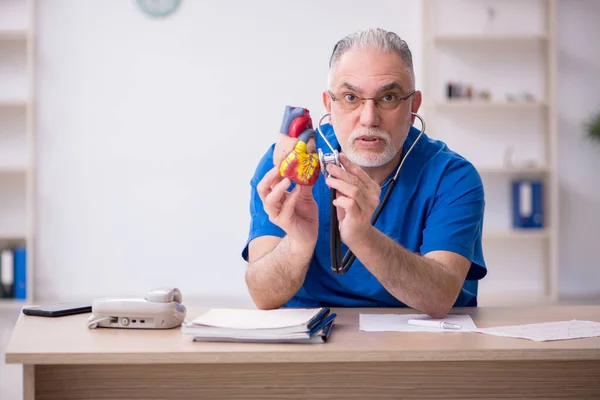 Gammal manlig läkare kardiolog arbetar på kliniken — Stockfoto