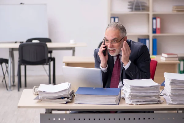高齢男性従業員と職場で多すぎる仕事 — ストック写真