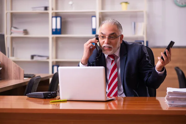 Old male employee sitting in the office — Stock Photo, Image