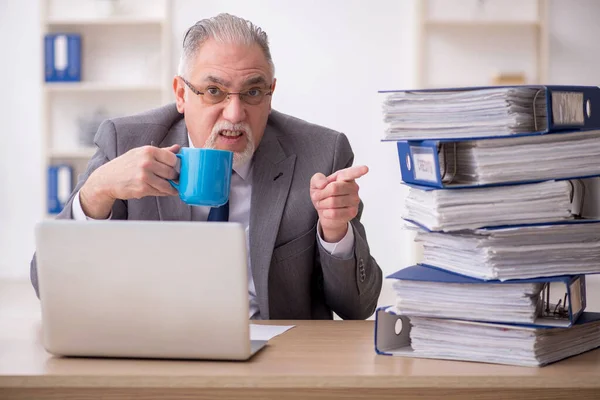 Alte männliche Angestellte unzufrieden mit exzessiver Arbeit im Büro — Stockfoto