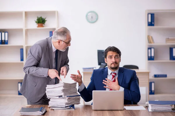 Två manliga anställda och för mycket arbete på kontoret — Stockfoto