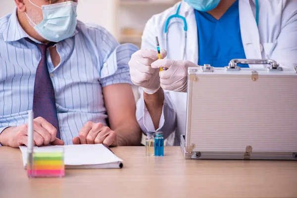 Jeune homme médecin visitant vieil homme d'affaires sur le lieu de travail — Photo