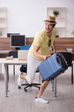 Genç bir erkek işçi iş yerinde geziye hazırlanıyor.