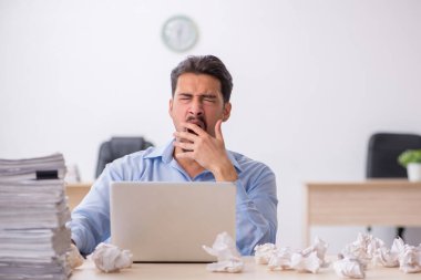 Genç bir erkek çalışan ofiste yeni fikirleri reddediyor.