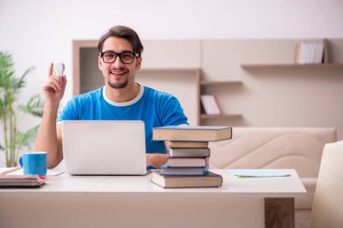 Evde okuyan genç bir erkek öğrenci.