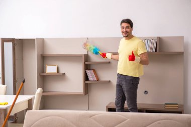 Genç erkek müteahhit evi temizliyor.