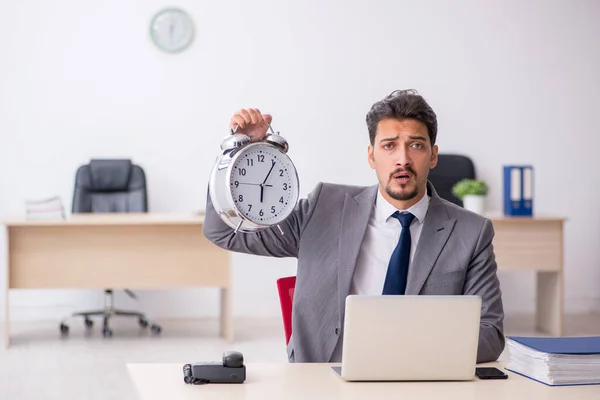 Joven empleado masculino en concepto de gestión del tiempo —  Fotos de Stock