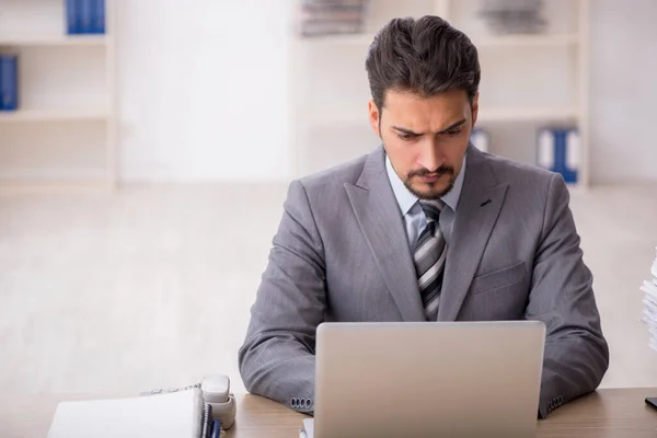 Jovem funcionário masculino infeliz com excesso de trabalho no escritório — Fotografia de Stock