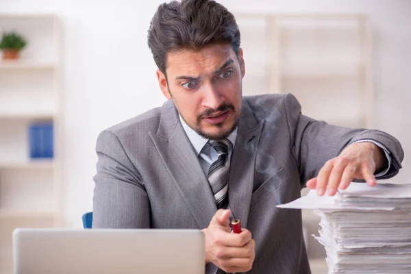 Jovem funcionário masculino infeliz com excesso de trabalho no escritório — Fotografia de Stock