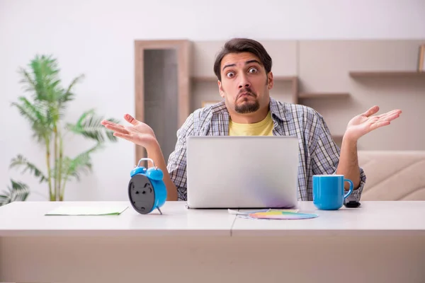 Giovane freelance di sesso maschile nel concetto di gestione del tempo a casa — Foto Stock