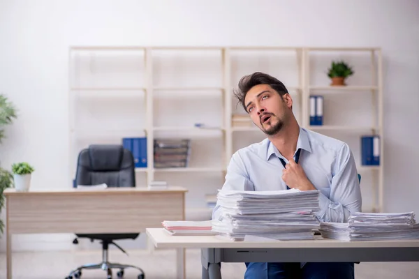 Jovem funcionário masculino infeliz com excesso de trabalho no escritório — Fotografia de Stock