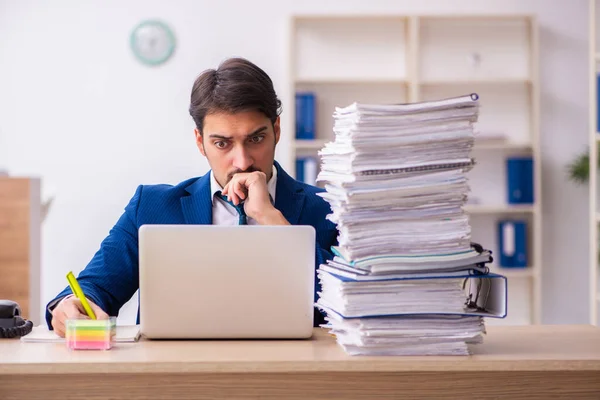 Junge männliche Mitarbeiter und zu viel Arbeit im Büro — Stockfoto