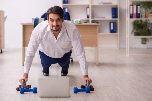 Ung manlig anställd som motionerar under pausen — Stockfoto