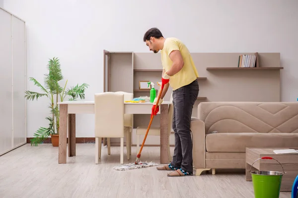 Joven contratista masculino limpiando la casa — Foto de Stock