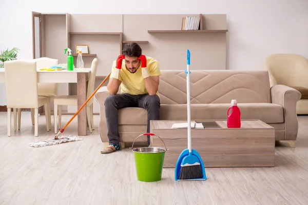 Joven contratista masculino limpiando la casa — Foto de Stock